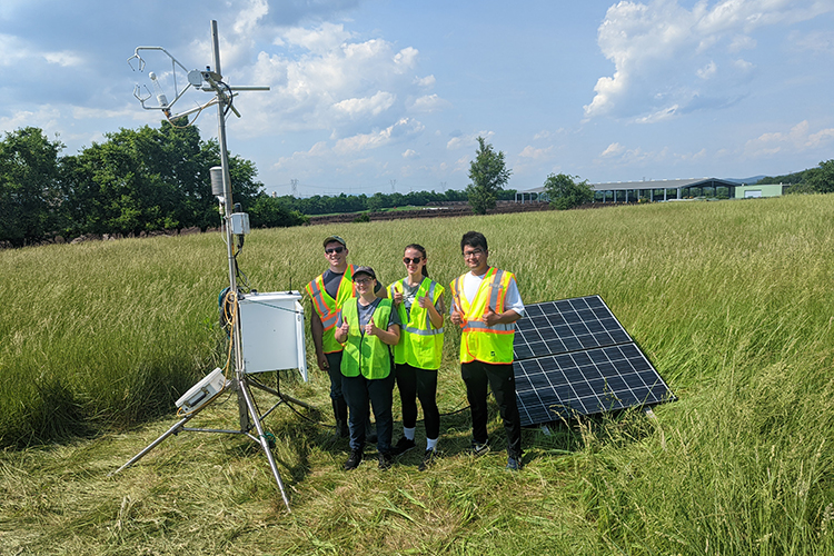 students in field with atmospheric instruments