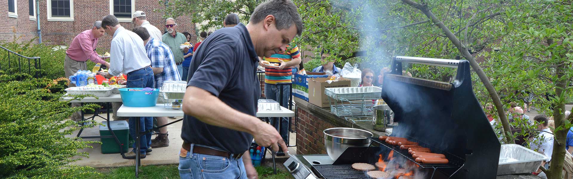 Bill Syrett grilling hotdogs at Irvin Interest House